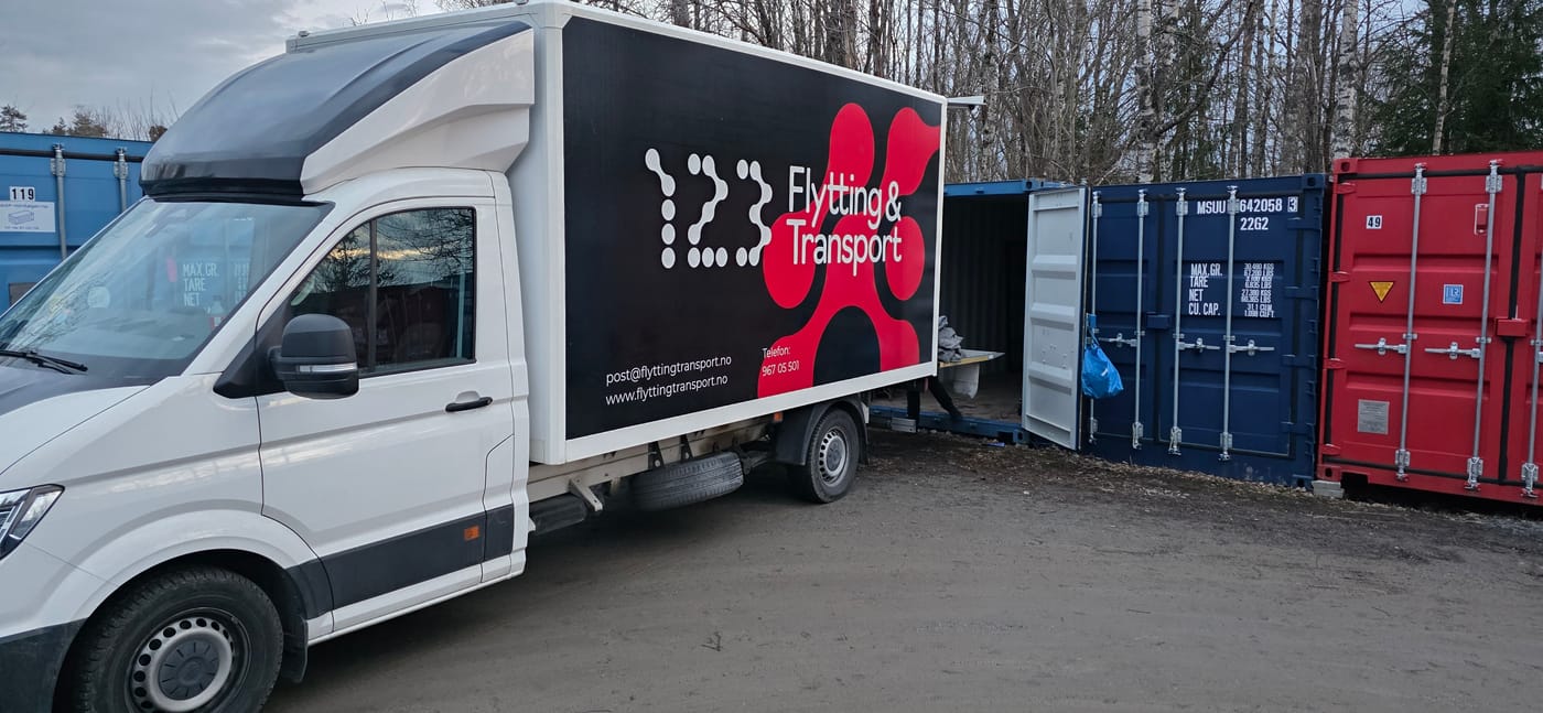 123 Flytting & Transport sin flyttebil ved lagercontainere.